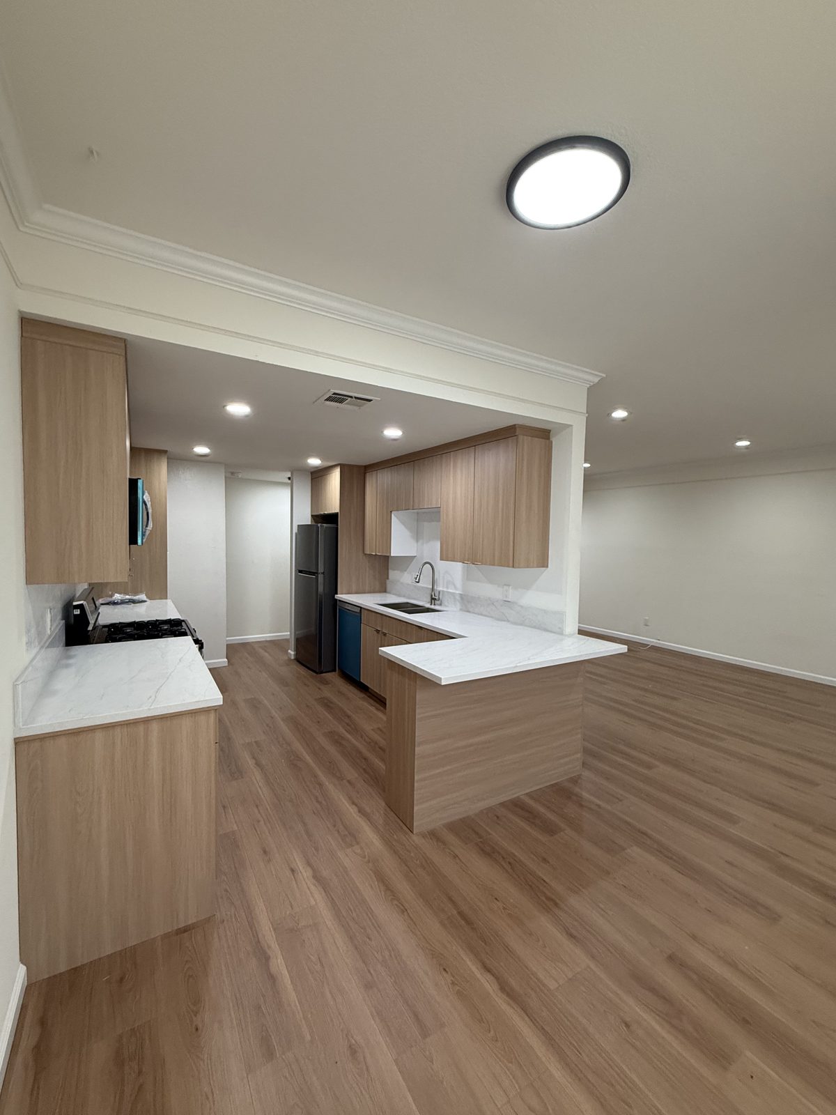 Finished kitchen with wood cabinetry, quartz countertops, and new appliances